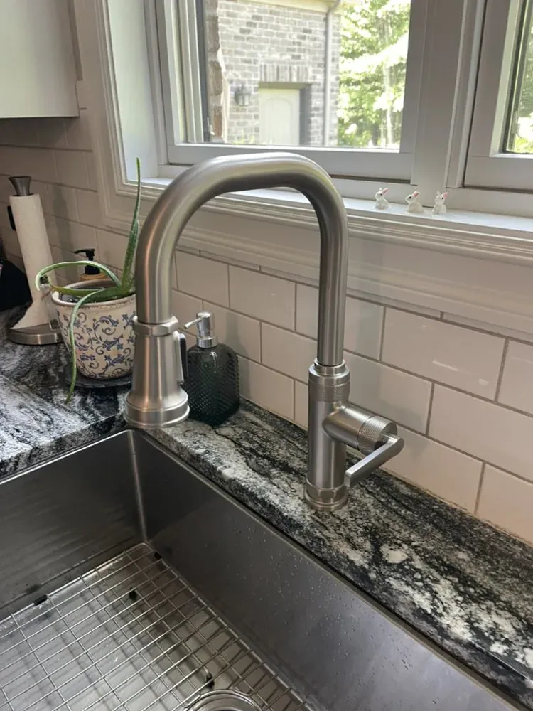 New pull-down kitchen faucet installed beside a stainless steel sink