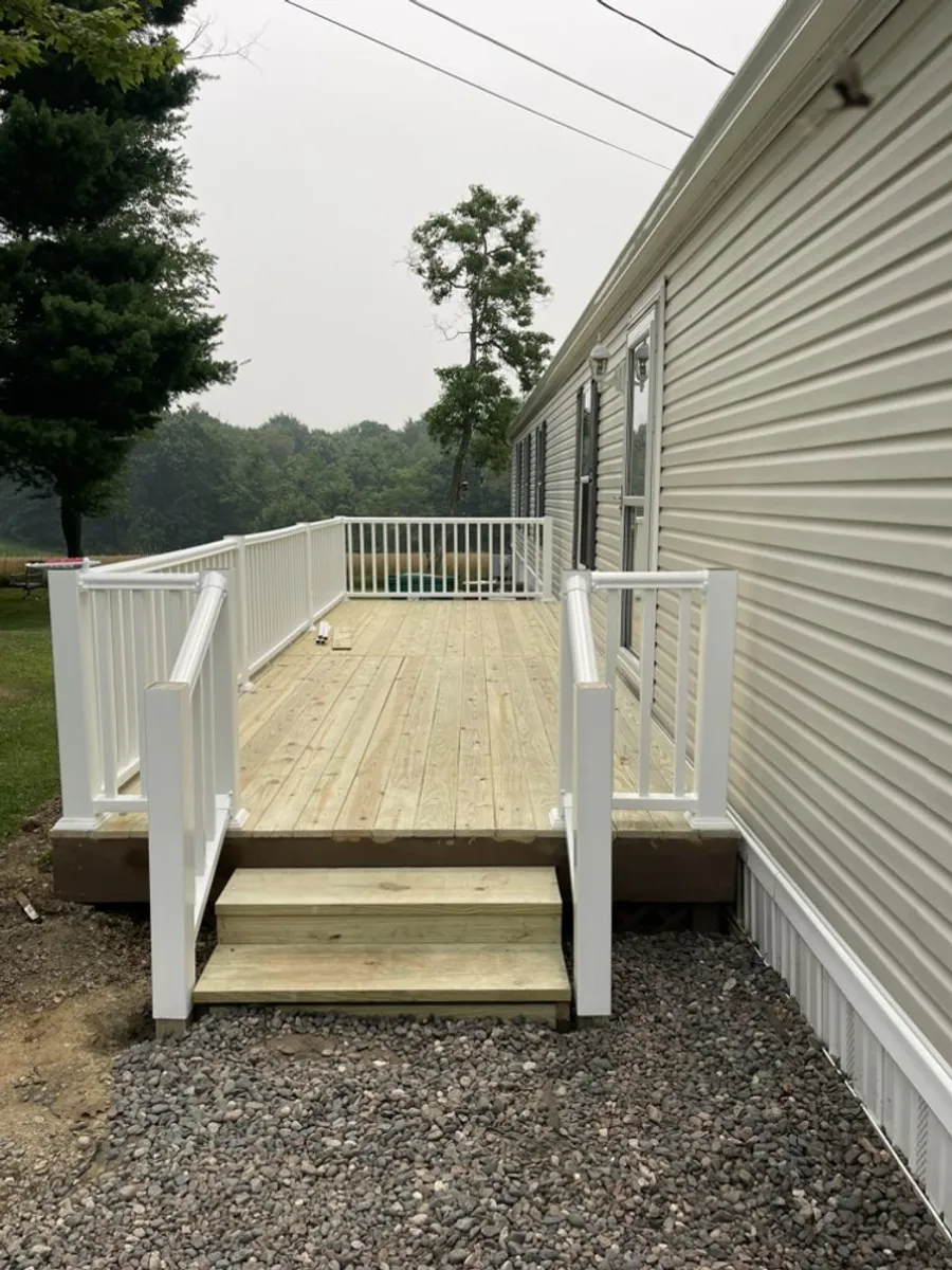 Completed wood deck with new white vinyl railings